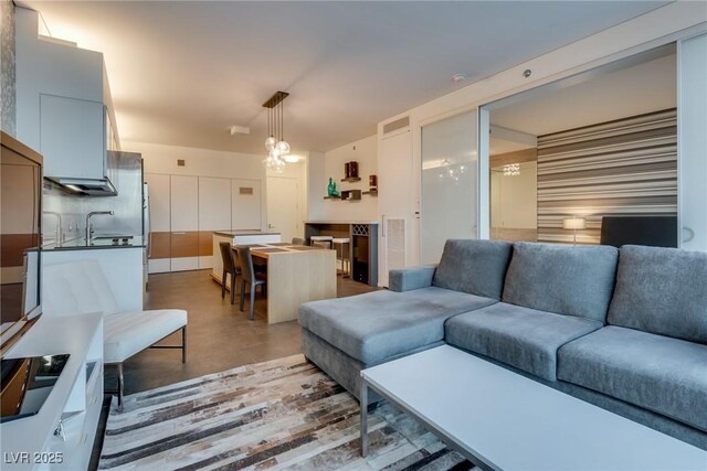 living room featuring sink and a notable chandelier