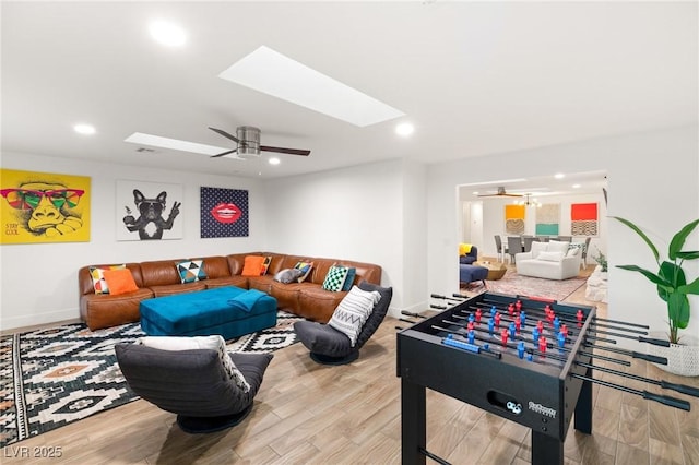 playroom featuring a skylight, ceiling fan, and hardwood / wood-style floors