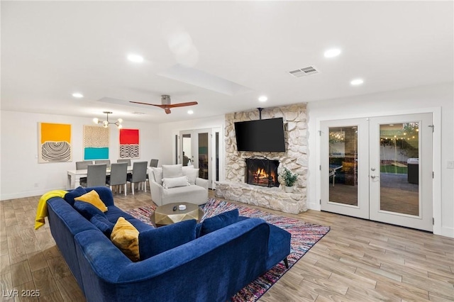 living room with a fireplace, french doors, and light hardwood / wood-style floors