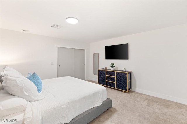 bedroom featuring light colored carpet and a closet