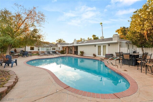 view of pool featuring french doors, cooling unit, and a patio area