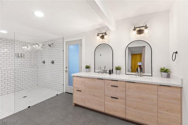 bathroom featuring beamed ceiling, a tile shower, vanity, and tile patterned flooring