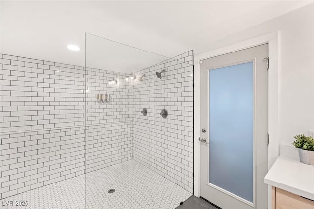 bathroom with tile patterned floors, vanity, and tiled shower