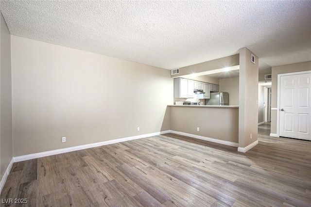 interior space featuring light hardwood / wood-style floors and a textured ceiling