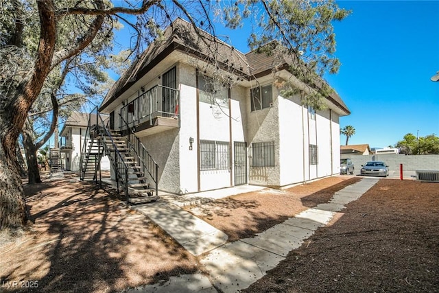 rear view of house with central air condition unit and a balcony