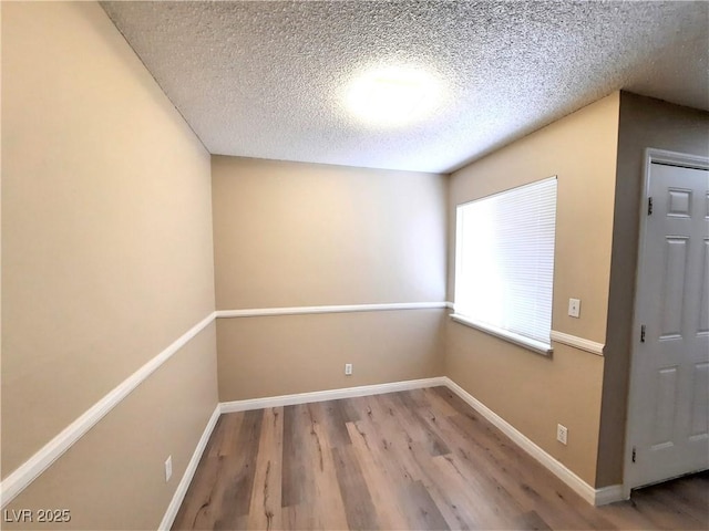 spare room featuring hardwood / wood-style flooring and a textured ceiling