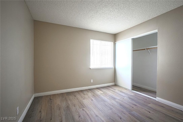 unfurnished bedroom featuring a closet, light hardwood / wood-style flooring, and a textured ceiling