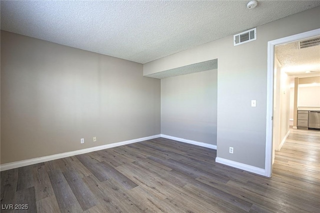 empty room featuring a textured ceiling and hardwood / wood-style flooring