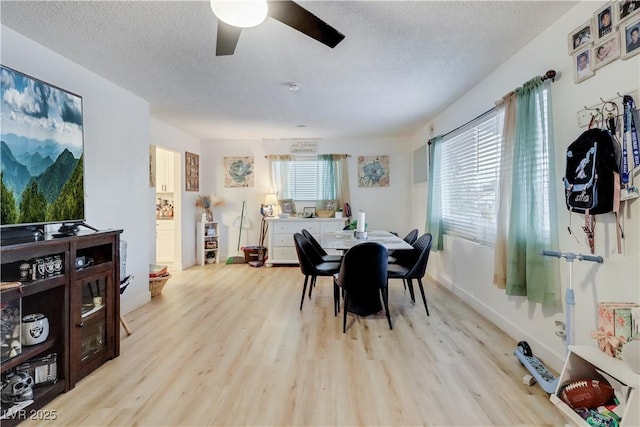 dining room featuring ceiling fan, light hardwood / wood-style floors, and a textured ceiling