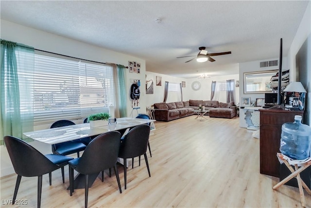 dining room featuring a textured ceiling, light hardwood / wood-style flooring, and ceiling fan