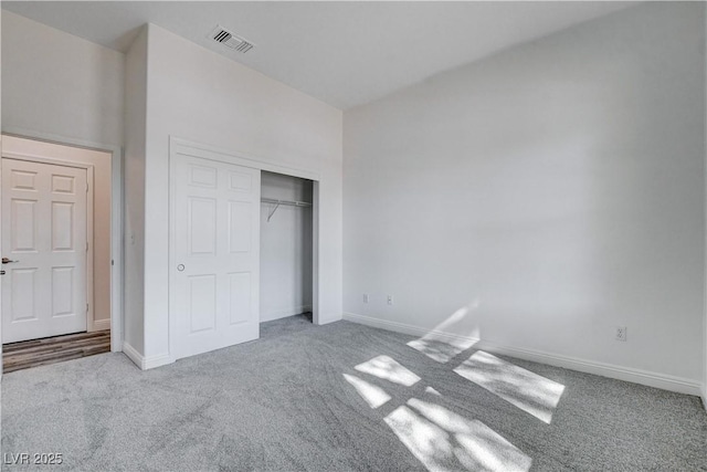 unfurnished bedroom featuring light carpet and a closet