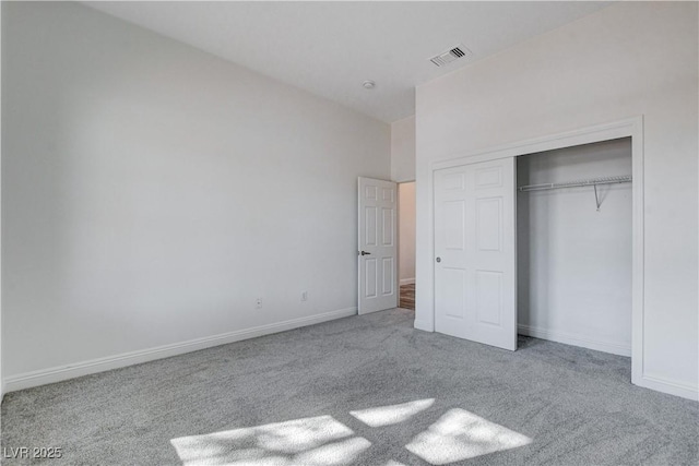 unfurnished bedroom featuring a closet and light colored carpet