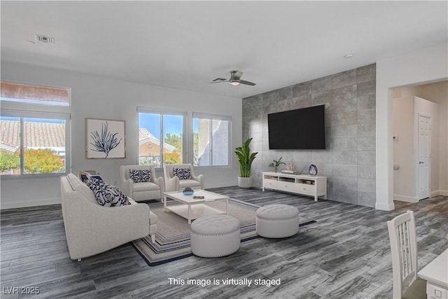 living room with dark hardwood / wood-style flooring, tile walls, a wealth of natural light, and ceiling fan