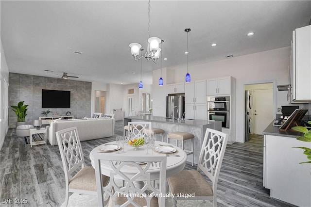 dining room featuring sink, dark hardwood / wood-style floors, and ceiling fan with notable chandelier