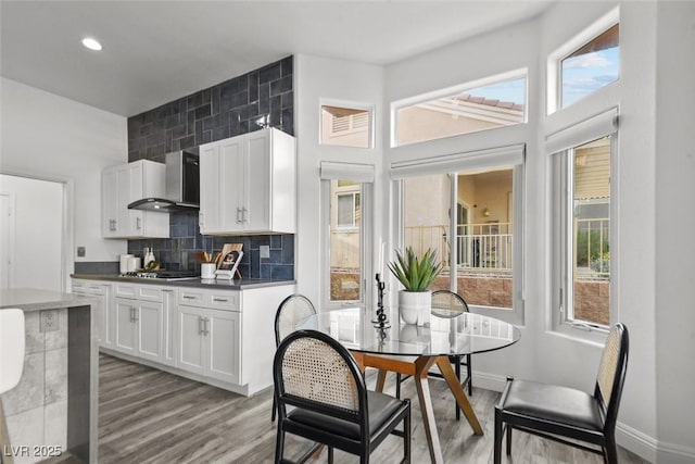 10300 Bent Brook Pl, Las Vegas, NV 89134 - kitchen with light wood-type flooring, wall chimney exhaust hood, a wealth of natural light, and white cabinetry