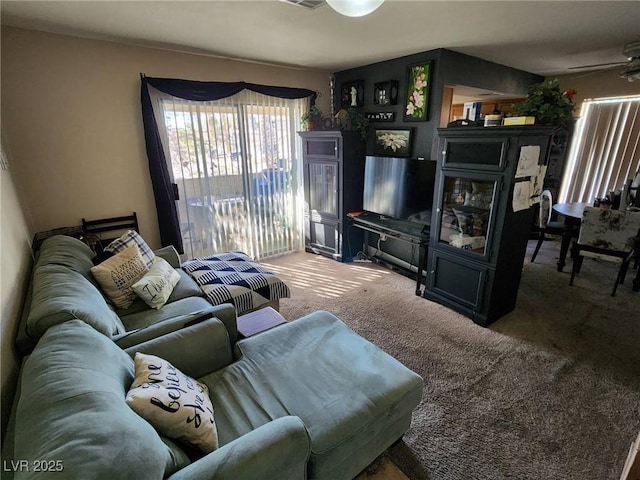 living room with ceiling fan and carpet