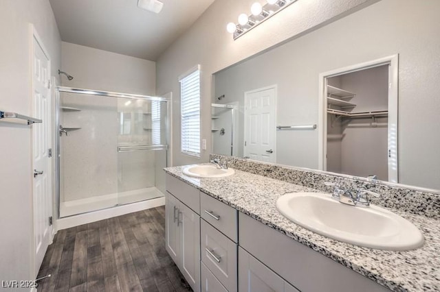 bathroom with a shower with door, vanity, and hardwood / wood-style flooring