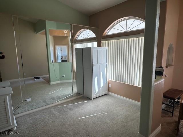 entryway featuring carpet flooring and vaulted ceiling