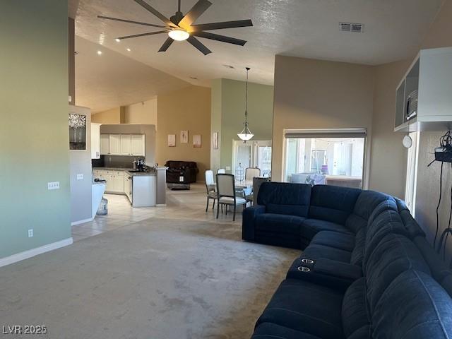 carpeted living room with ceiling fan, a fireplace, and lofted ceiling