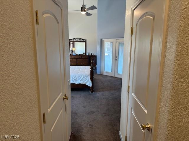 bedroom with ceiling fan, dark carpet, and french doors