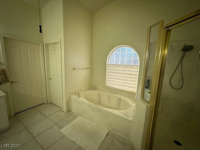 bathroom featuring tile patterned floors, independent shower and bath, and lofted ceiling