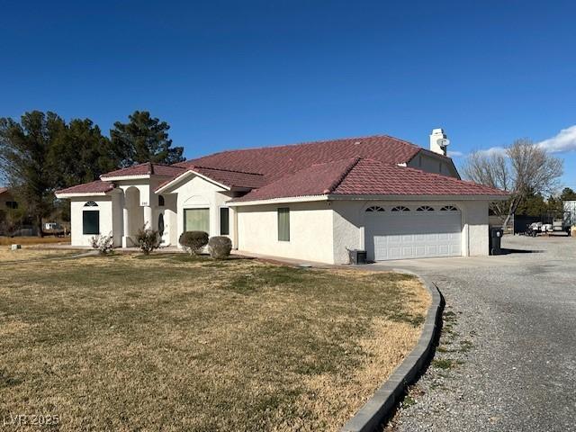 mediterranean / spanish-style home featuring a garage and a front lawn