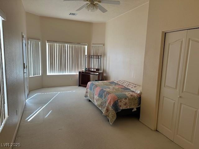 carpeted bedroom featuring a closet and ceiling fan