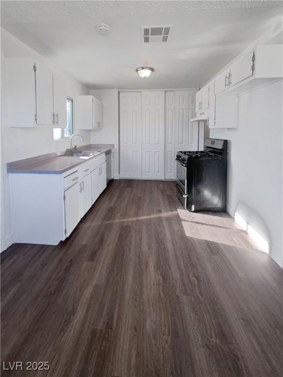 kitchen featuring dishwasher, white cabinets, sink, dark hardwood / wood-style floors, and gas stove