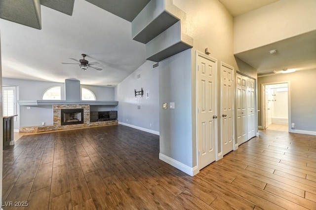 unfurnished living room featuring hardwood / wood-style flooring, ceiling fan, and a fireplace