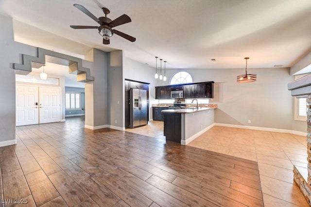 kitchen featuring ceiling fan, sink, kitchen peninsula, vaulted ceiling, and appliances with stainless steel finishes