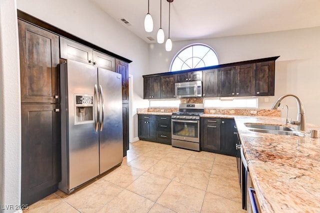 kitchen with dark brown cabinets, stainless steel appliances, hanging light fixtures, and sink