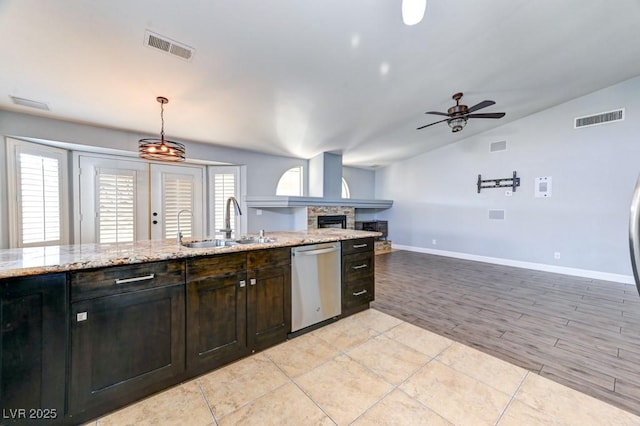 kitchen featuring ceiling fan, dishwasher, sink, pendant lighting, and lofted ceiling