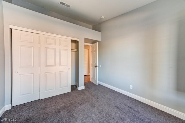 unfurnished bedroom featuring a closet and dark carpet