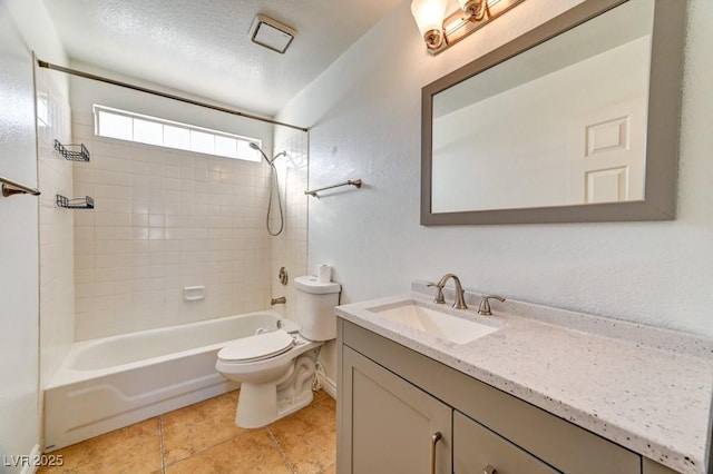 full bathroom featuring vanity, tiled shower / bath, tile patterned flooring, toilet, and a textured ceiling