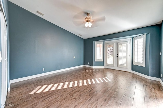 empty room featuring french doors, dark hardwood / wood-style flooring, and ceiling fan