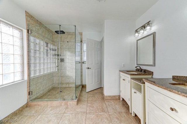 bathroom with tile patterned floors, vanity, and a shower with shower door