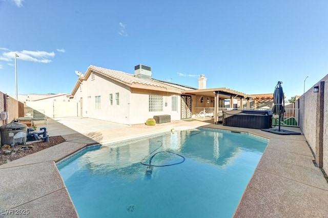 exterior space featuring a swimming pool with hot tub, a patio, and central AC unit