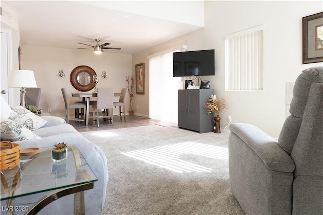 living area featuring ceiling fan and carpet