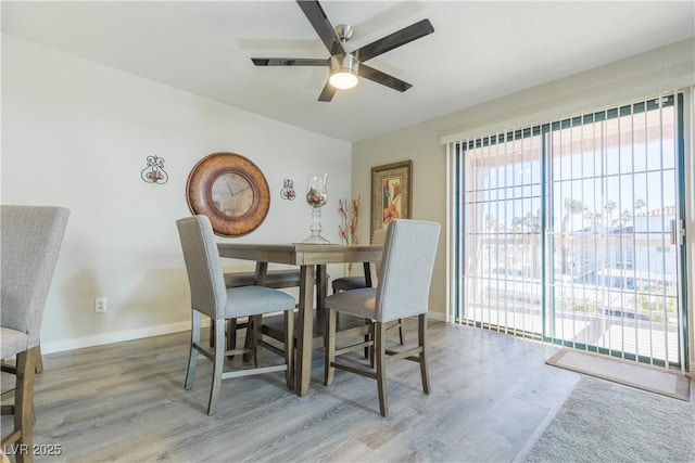 dining space with baseboards, a ceiling fan, and light wood-style floors