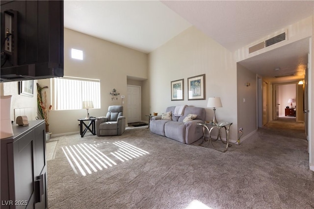 living area featuring light carpet, a towering ceiling, visible vents, and baseboards