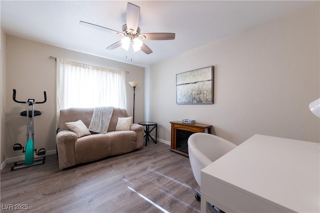 office space featuring baseboards, a ceiling fan, and wood finished floors