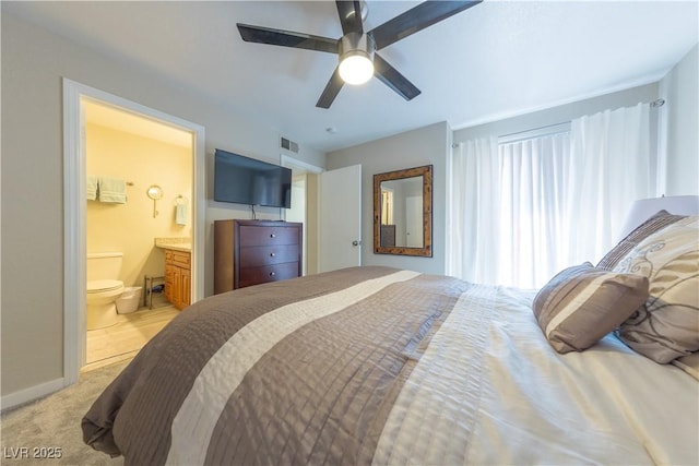 bedroom featuring baseboards, visible vents, light colored carpet, ceiling fan, and ensuite bathroom