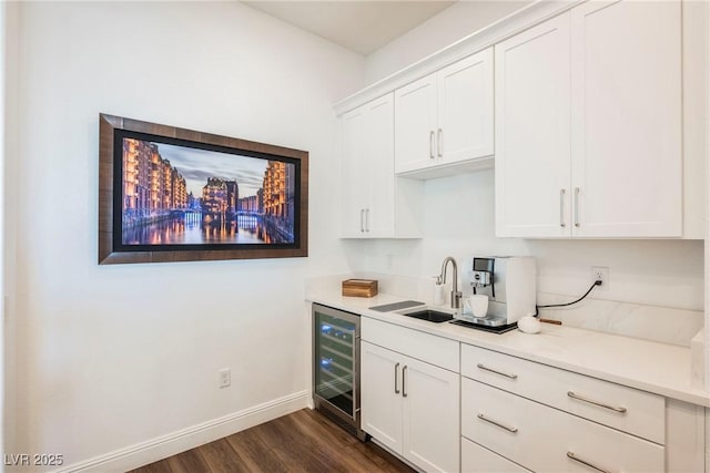 interior space featuring dark wood-type flooring, beverage cooler, white cabinetry, and sink