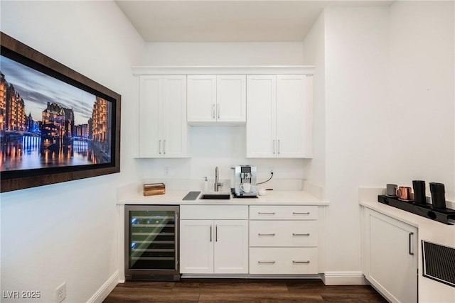 bar featuring sink, white cabinets, beverage cooler, and dark hardwood / wood-style floors