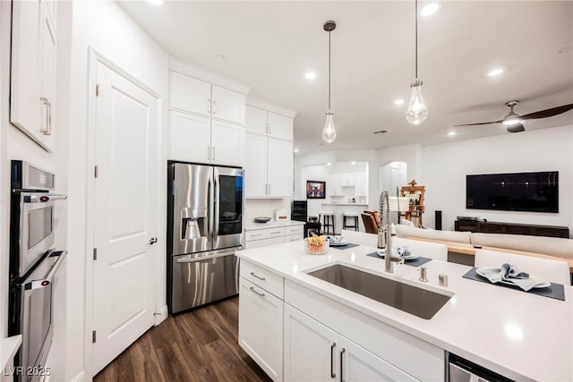 kitchen with white cabinets, appliances with stainless steel finishes, hanging light fixtures, and sink