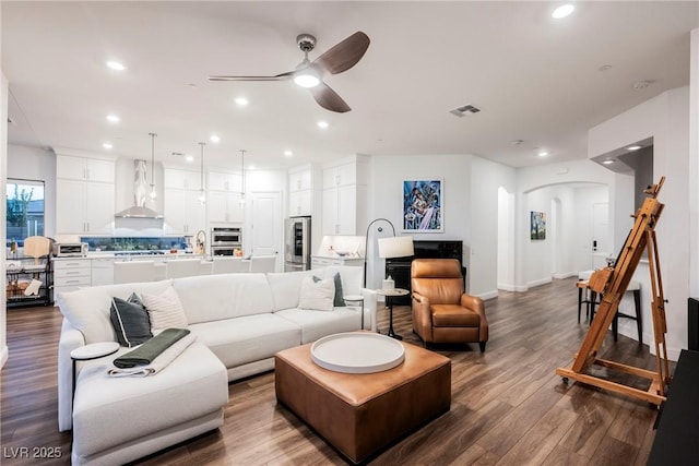 living room with ceiling fan and wood-type flooring