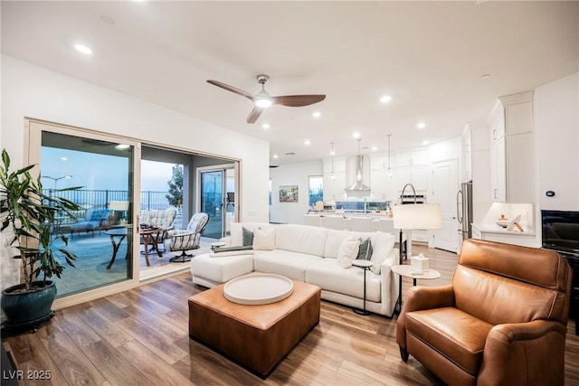 living room with ceiling fan and light wood-type flooring