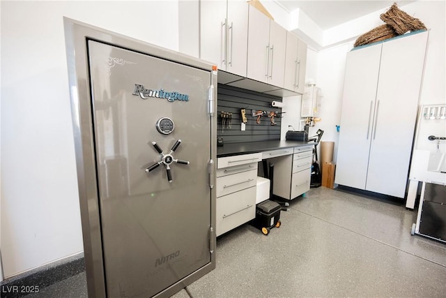 kitchen featuring water heater and white cabinets