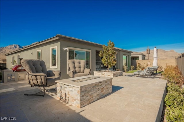 rear view of house featuring a patio, a fire pit, and a mountain view