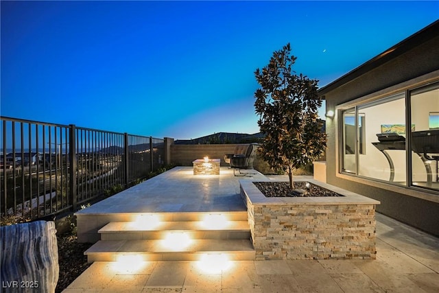 patio terrace at dusk with an outdoor fire pit and a mountain view